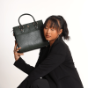 A girl sitting in formal dress carrying a MIVA Forest green color bag