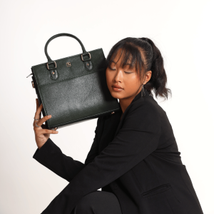 A girl sitting in formal dress carrying a MIVA Forest green color bag