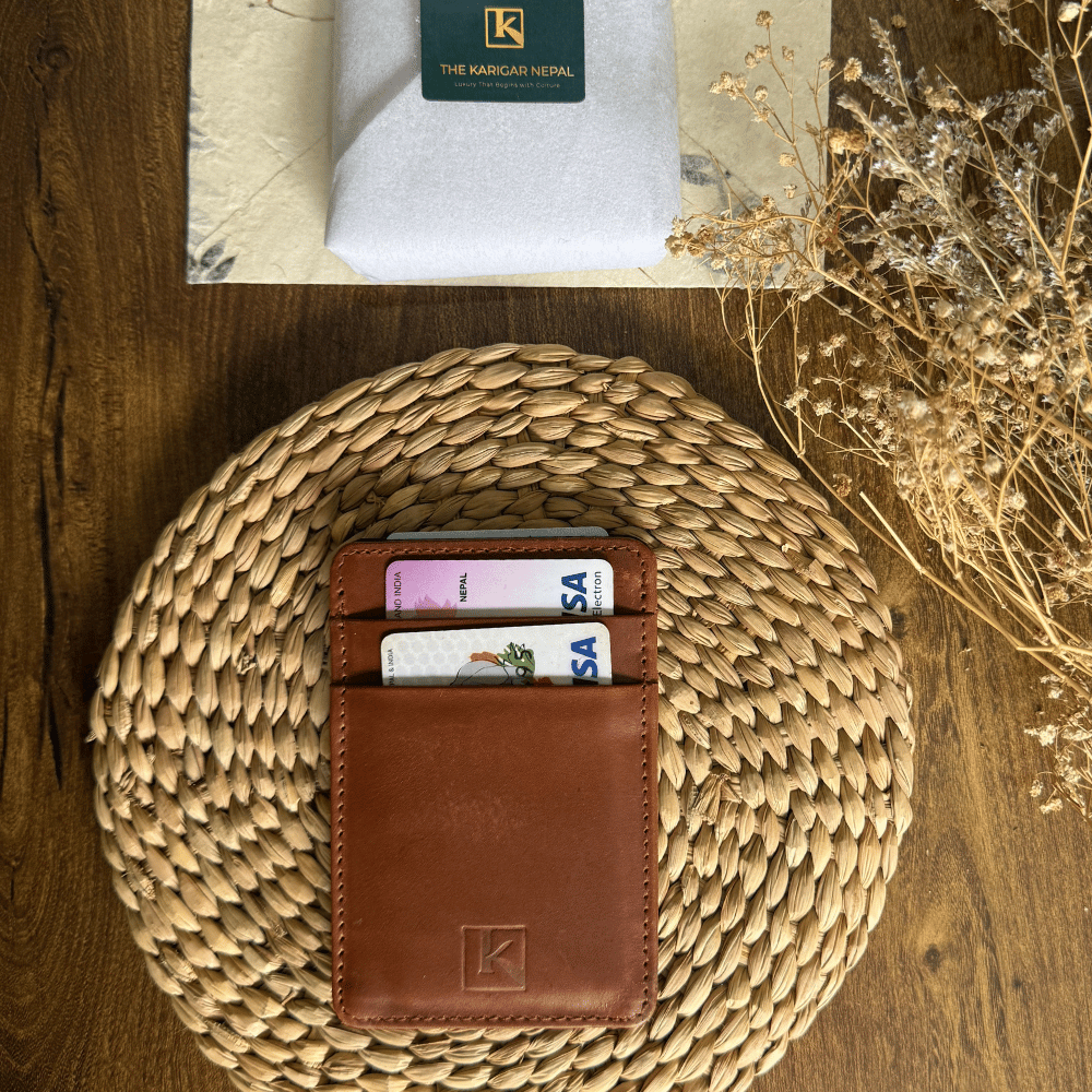 A image of a tan colored leather cardholder placed in a wooden table with flowers.