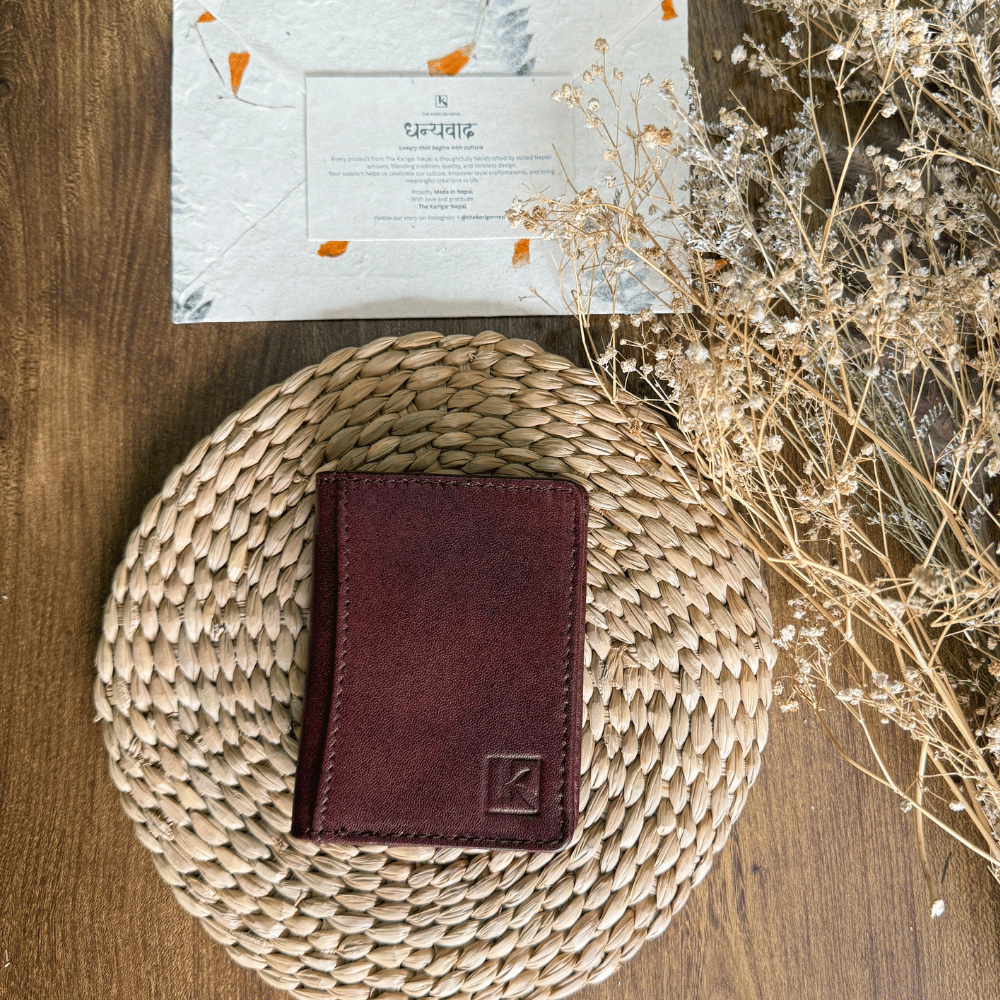 A unisex brown slim leather wallet placed in a wooden table.