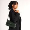 A girl in formal black dress carrying a Elira Green color leather bag.