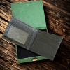A picture of opened black wallet placed on a green box at the wooden table.