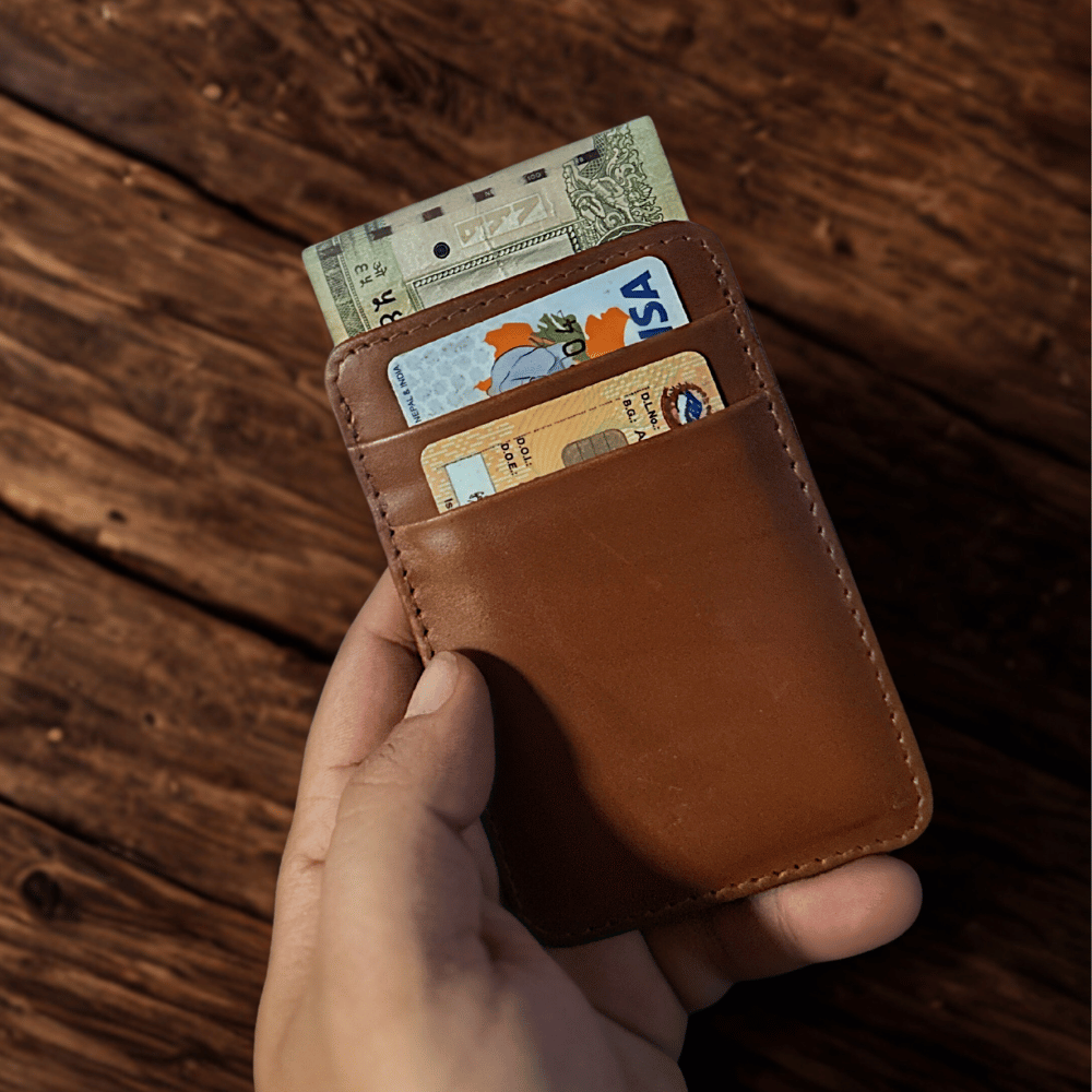 A back view of a tan color cardholder with some cards and money