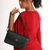 A girl standing and wearing a red dress posing with Elira Green leather bag.