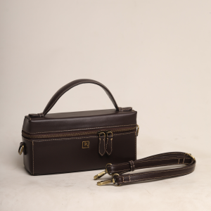 hree-quarter view of the brown leather Nova Bag by The Karigar Nepal with its detachable shoulder strap placed neatly beside it.